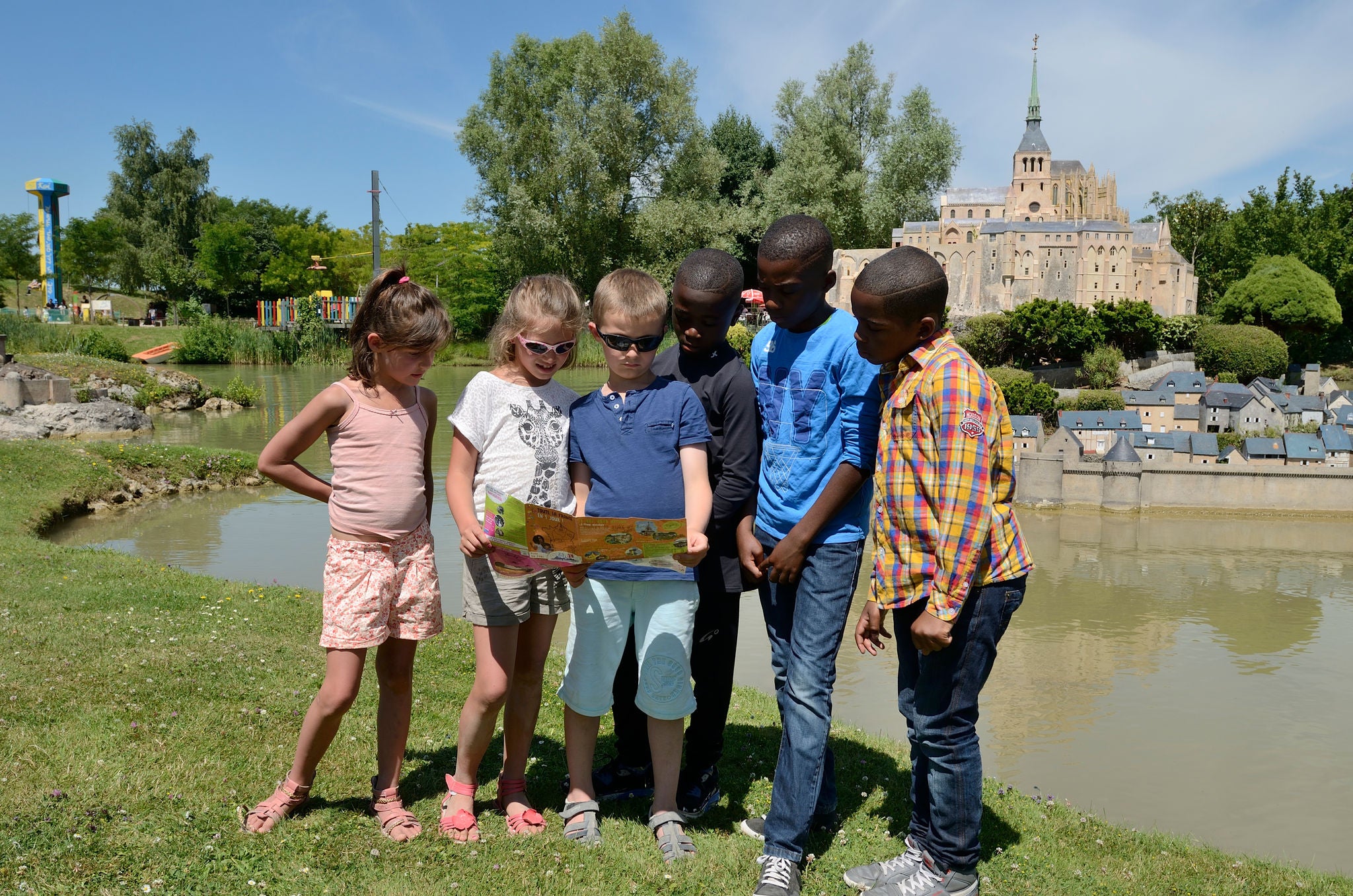 Group of kids are looking at the park map in France Miniature 